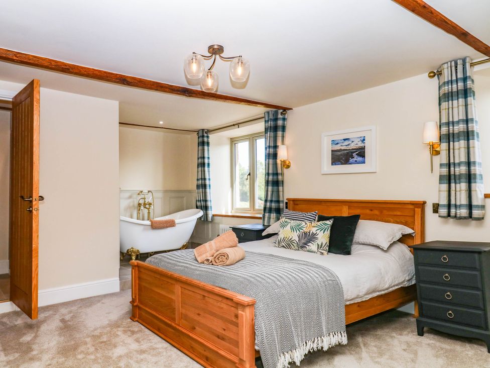 A bedroom with a bed and bathtub at Higher Weekaborough Farm in Coombe Fishacre near Ipplepen