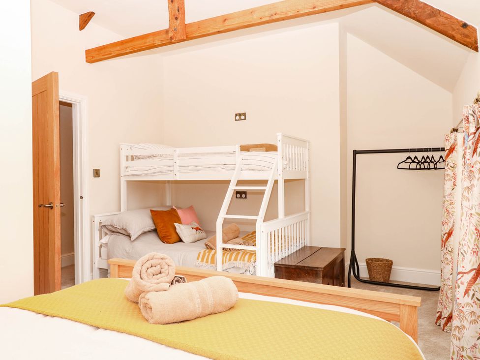 A bedroom with bunk beds and a double bed at Higher Weekaborough Farm near Coombe Fishacre near Ipplepen