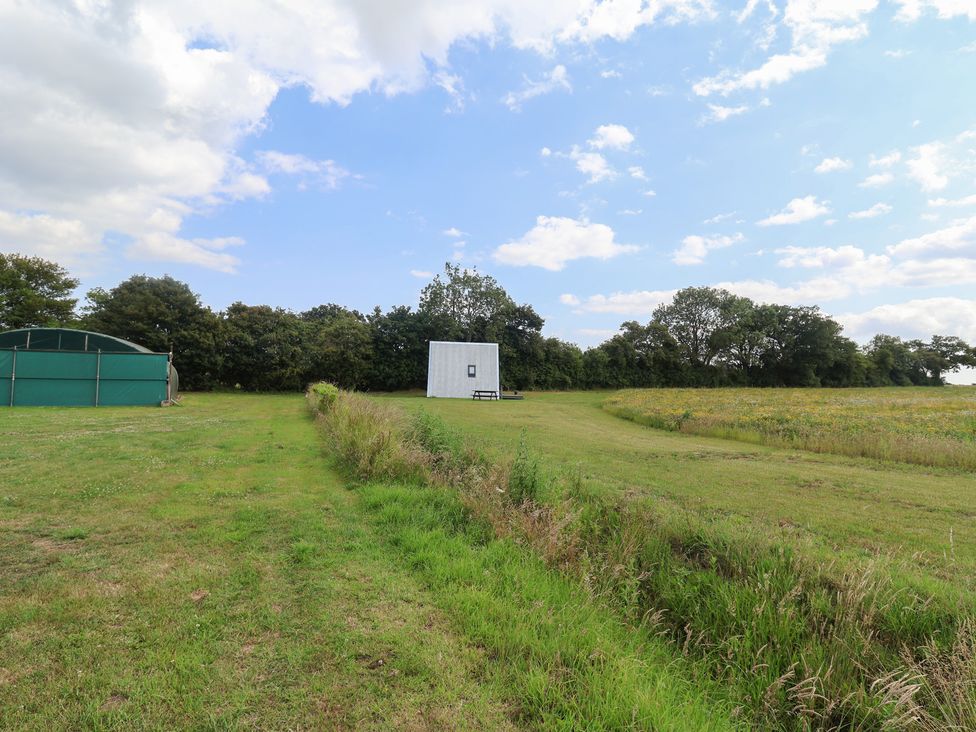A field with a building and trees at Robin A-frame in Monewden near Otley, Suffolk