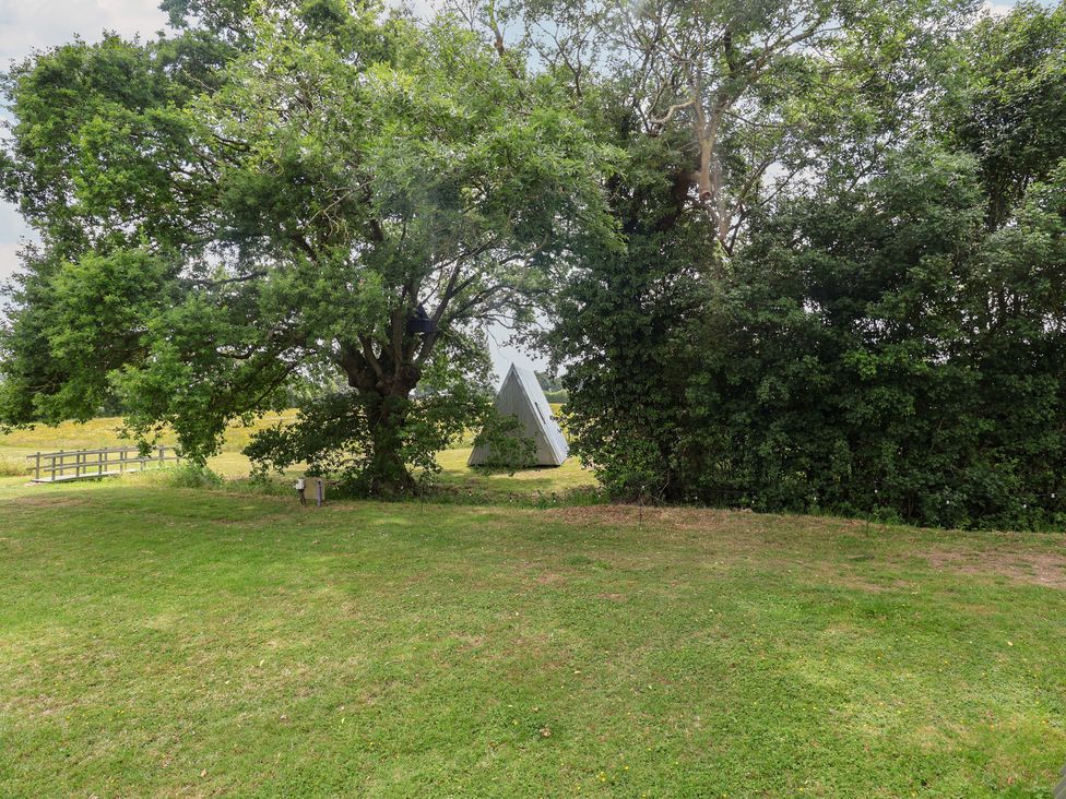 An A-frame structure surrounded by trees and grass at Robin A-frame in Monewden near Otley, Suffolk