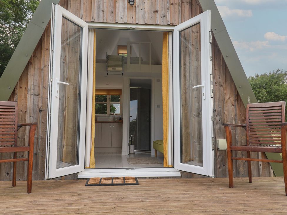 An outdoor area with chairs and open doors at A-frame Monewden near Otley Suffolk
