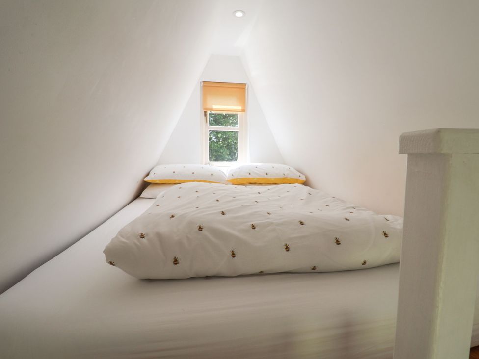 A bedroom with a bed and window at A-frame in Monewden near Otley, Suffolk