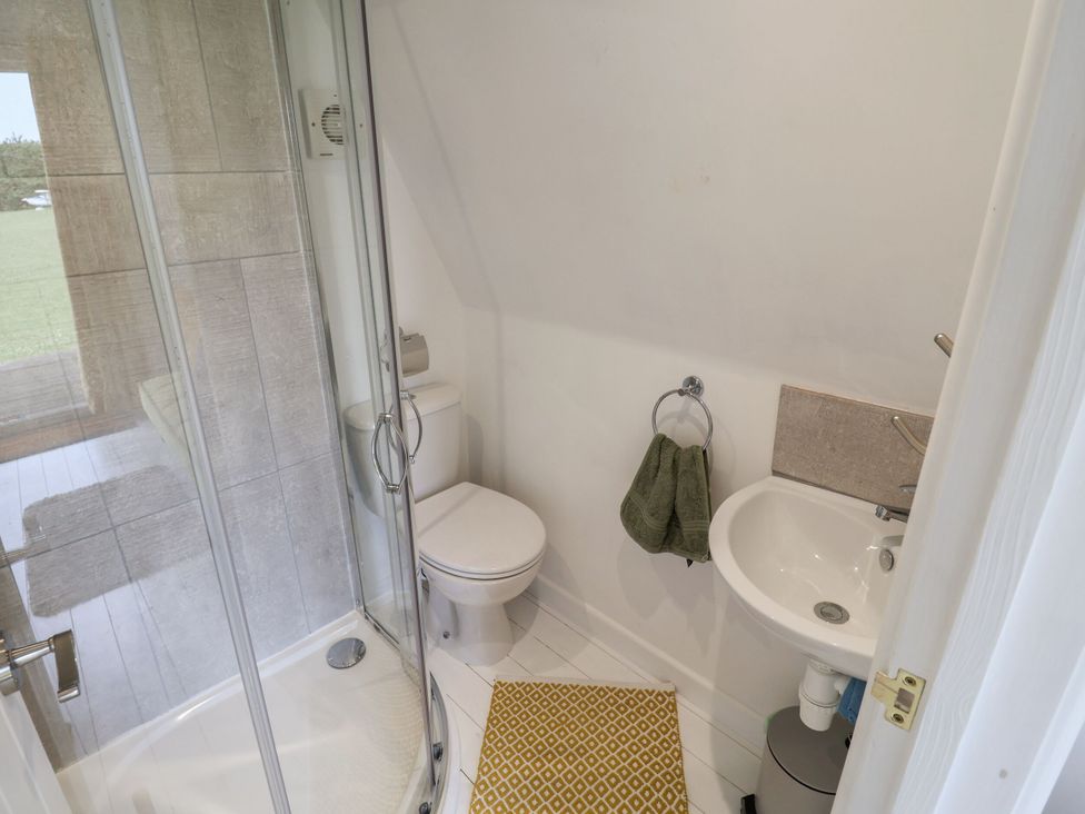 A bathroom with a shower, toilet, and sink at A-frame in Monewden near Otley, Suffolk