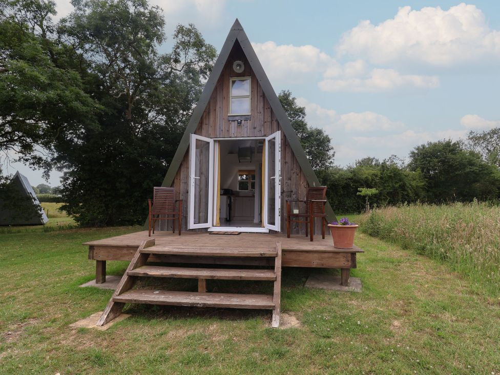 An A-frame structure with a wooden deck and chairs at A-frame in Monewden near Otley, Suffolk