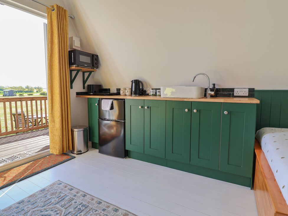 A kitchen area with a sink, kettle, microwave, and fridge at A-frame Monewden near Otley, Suffolk