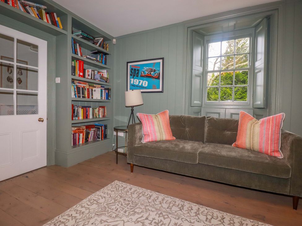 A study with bookshelves and a sofa at Vosporth Villa in Newquay