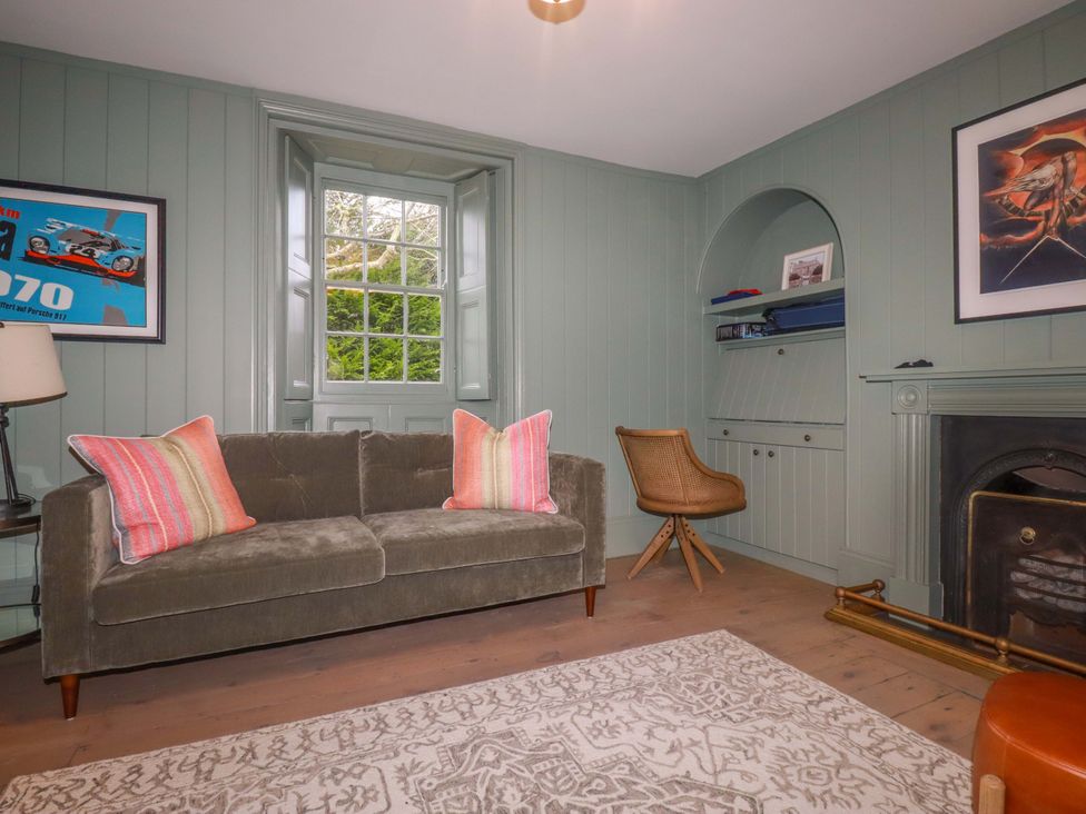 A living room with a sofa and lamp at Vosporth Villa in Newquay