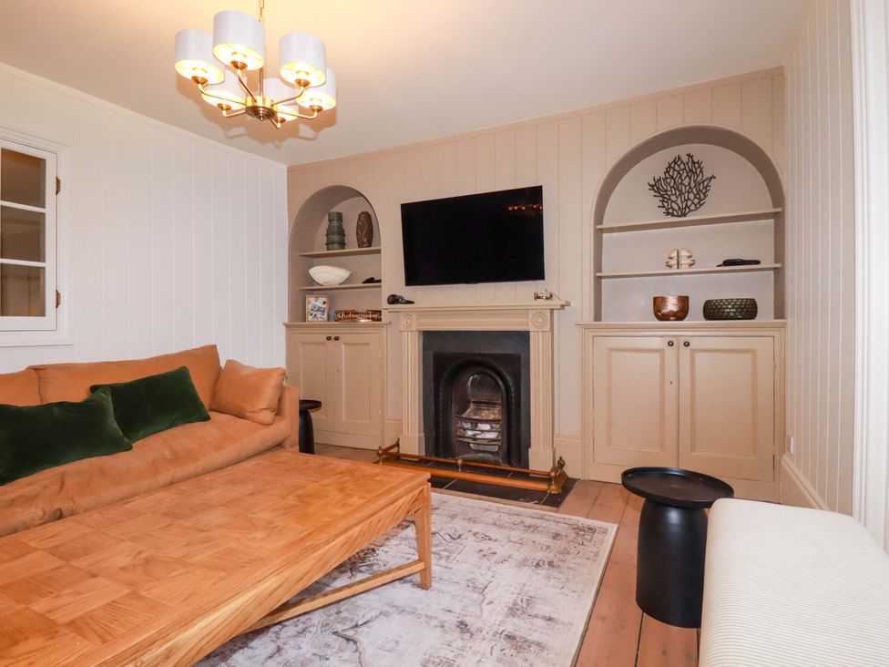 A living room with a sofa and fireplace at Vosporth Villa in Newquay