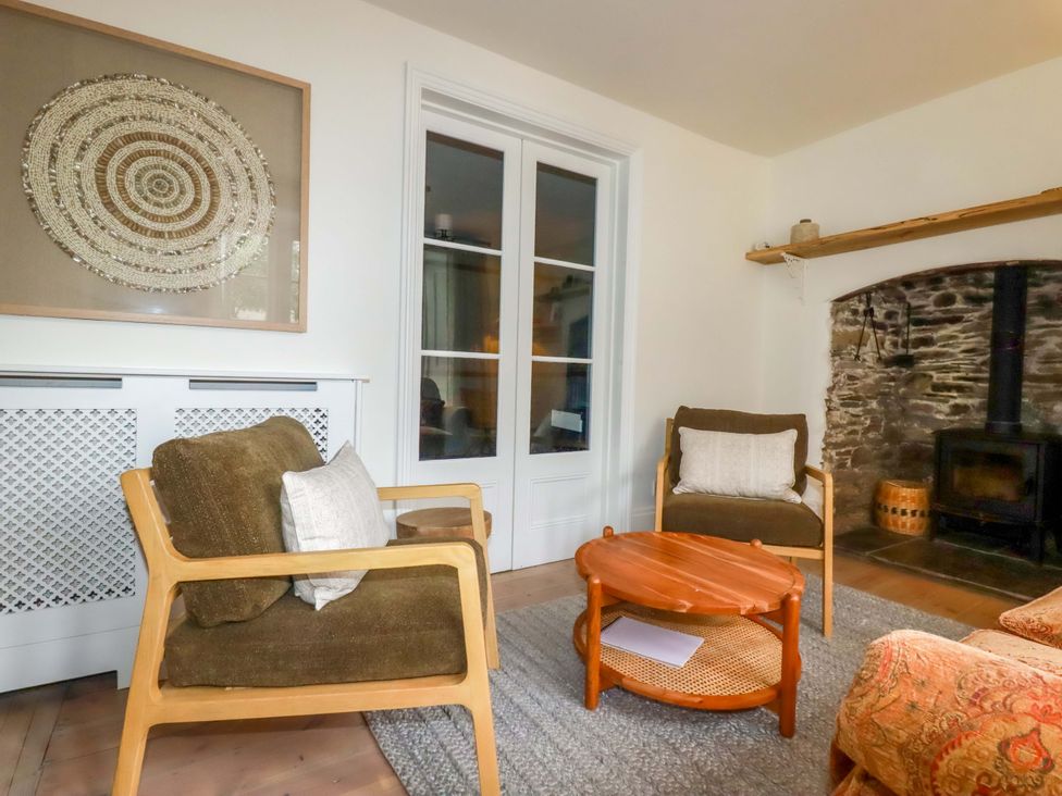A living room with armchairs and a coffee table at Vosporth Villa in Newquay