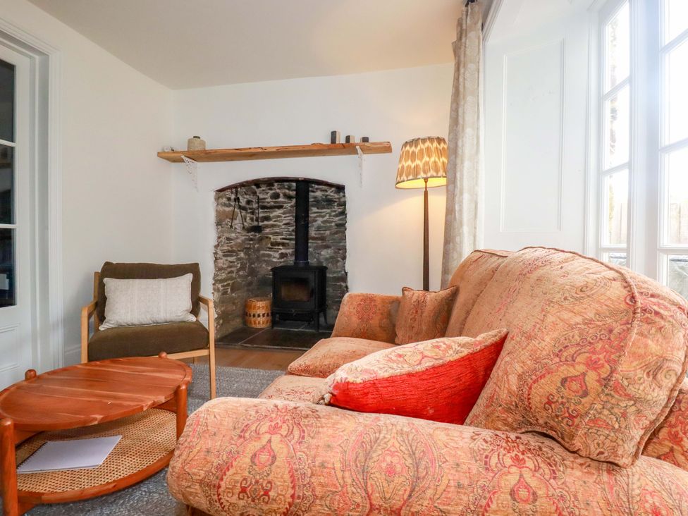 A living room with a stone fireplace at Vosporth Villa in Newquay