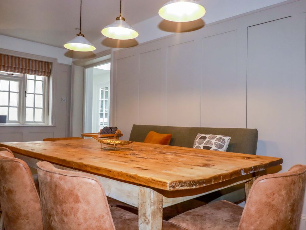 A dining room with a wooden table and chairs at Vosporth Villa Newquay