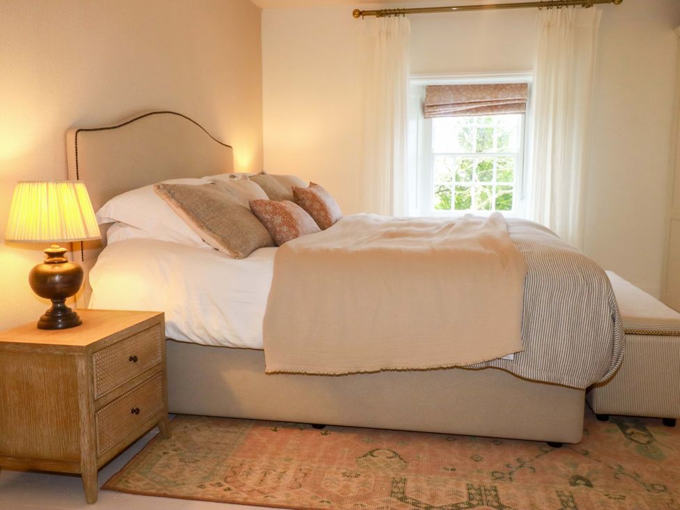 A bedroom with a bed and lamp at Vosporth Villa in Newquay