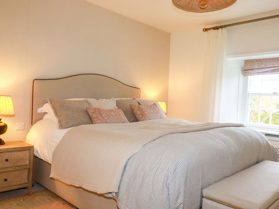A bedroom with a bed and bedside table at Vosporth Villa Newquay