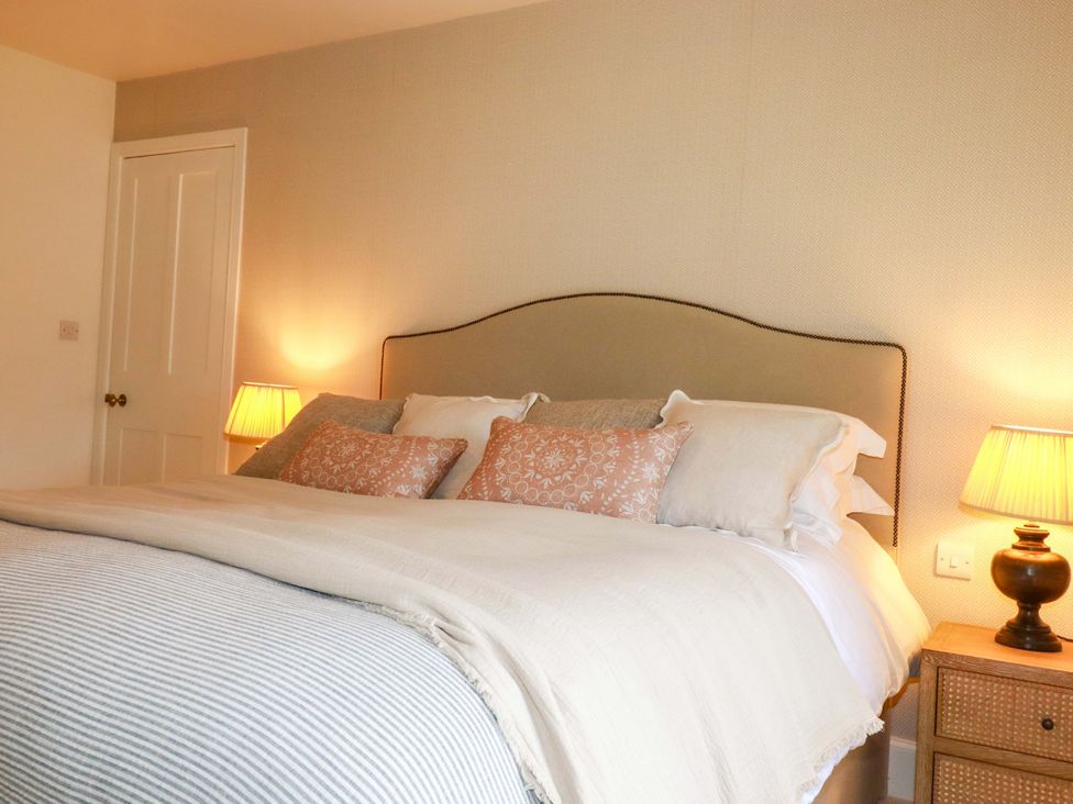 A bedroom with a bed and lamps at Vosporth Villa in Newquay