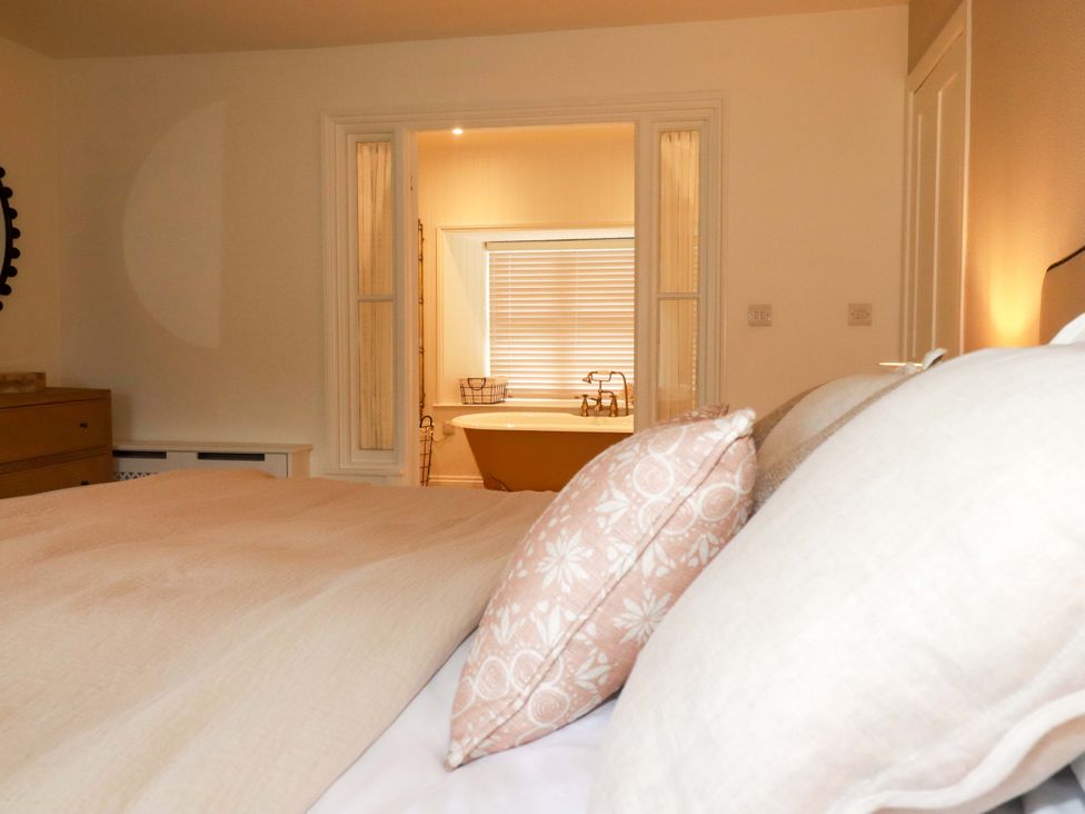 A bedroom with a view to a bathroom at Vosporth Villa in Newquay