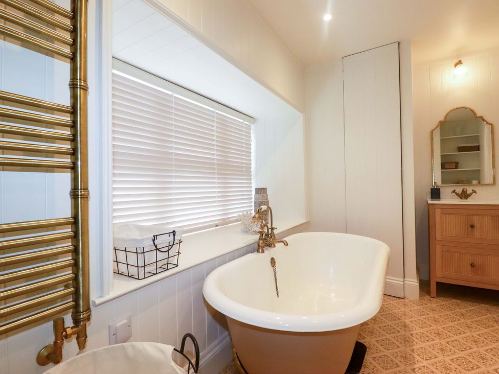 A bathroom featuring a bathtub near a window at Vosporth Villa in Newquay