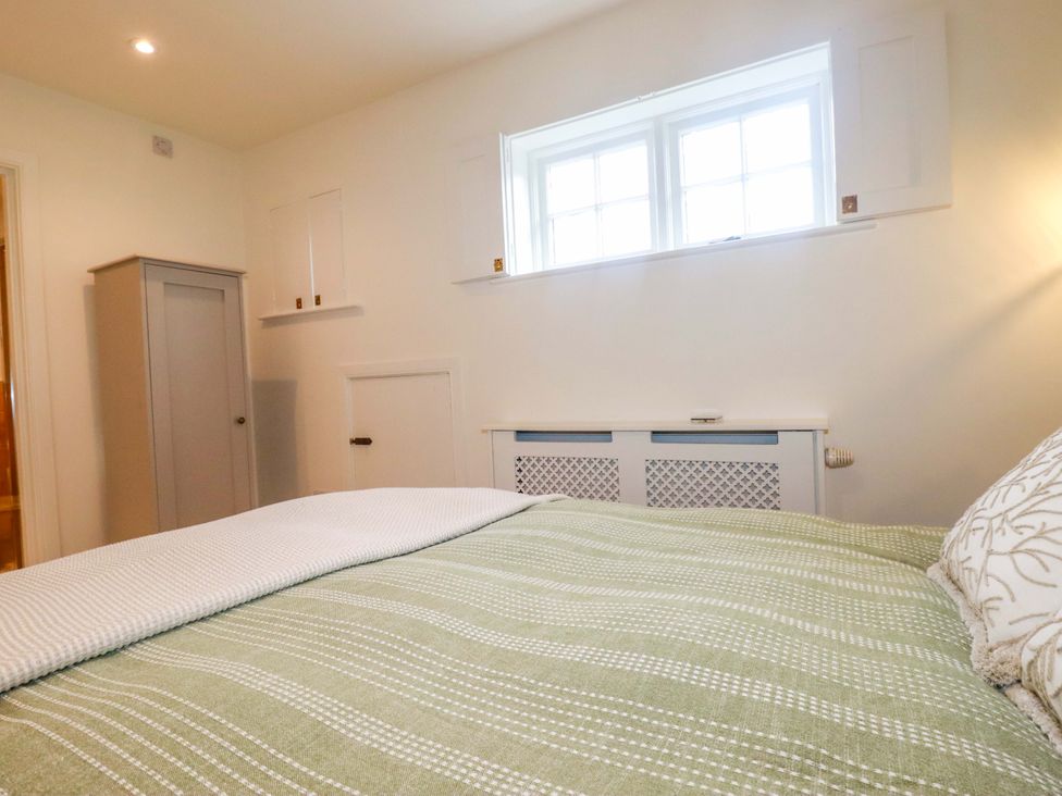 A bedroom with a bed and wardrobe at Vosporth Villa in Newquay