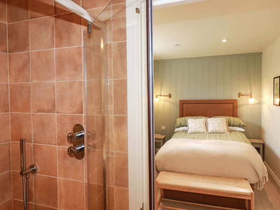 A bedroom with a bed and shower area at Vosporth Villa in Newquay