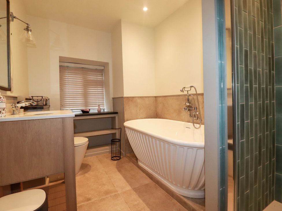 A bathroom with a bathtub, sink, and toilet at Vosporth Villa in Newquay