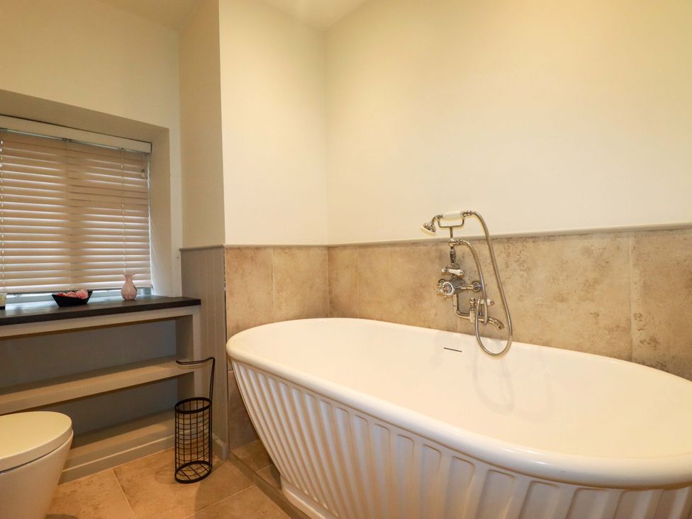 A bathroom with a bathtub, toilet, and sink at Vosporth Villa in Newquay