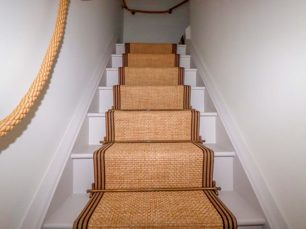 Staircase with runner and handrail at Vosporth Villa in Newquay