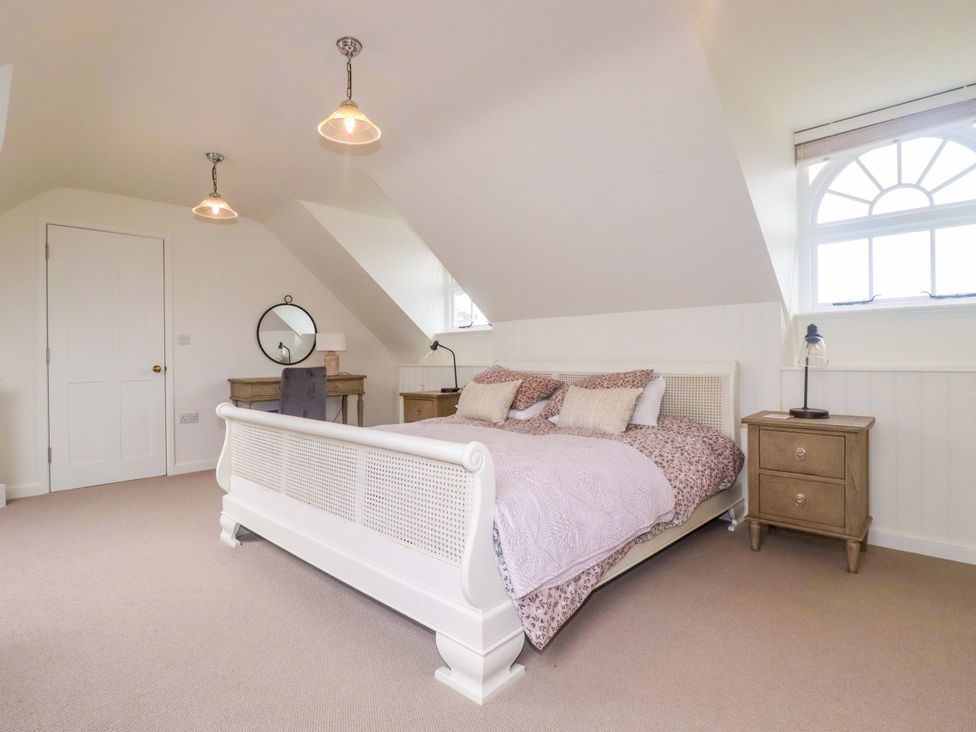 A bedroom with a bed and nightstands at Vosporth Villa in Newquay