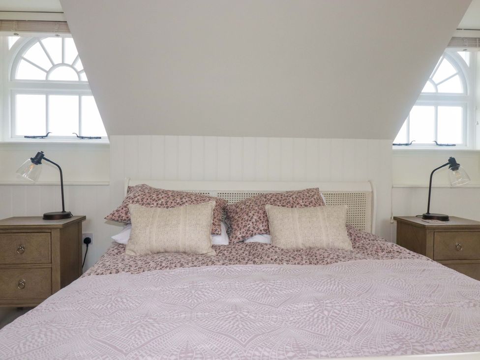 A bedroom with a bed and bedside tables at Vosporth Villa in Newquay