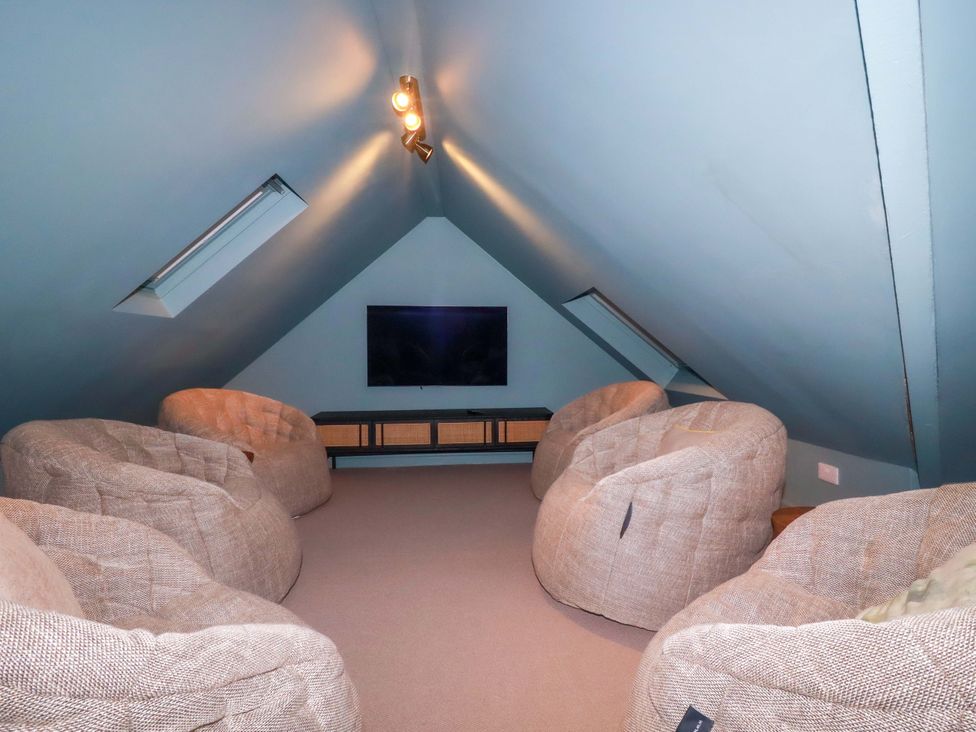 An attic with bean bags and a television at Vosporth Villa in Newquay