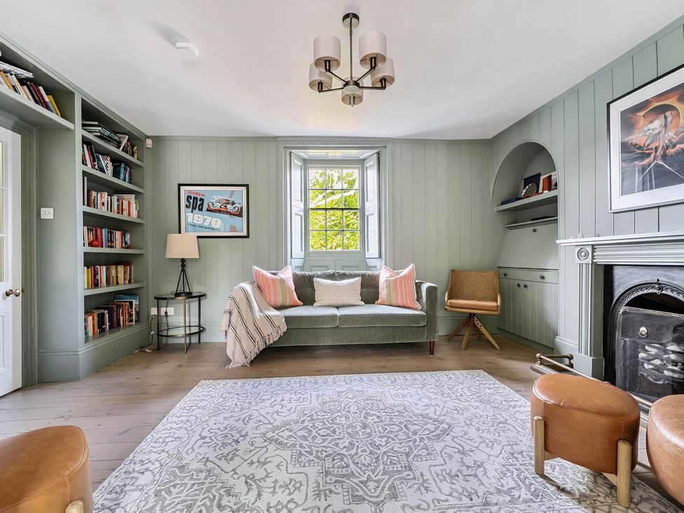 A living room with a sofa and bookshelf at Vosporth Villa in Crantock