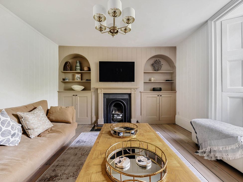 A living room with a coffee table and television at Vosporth Villa Crantock