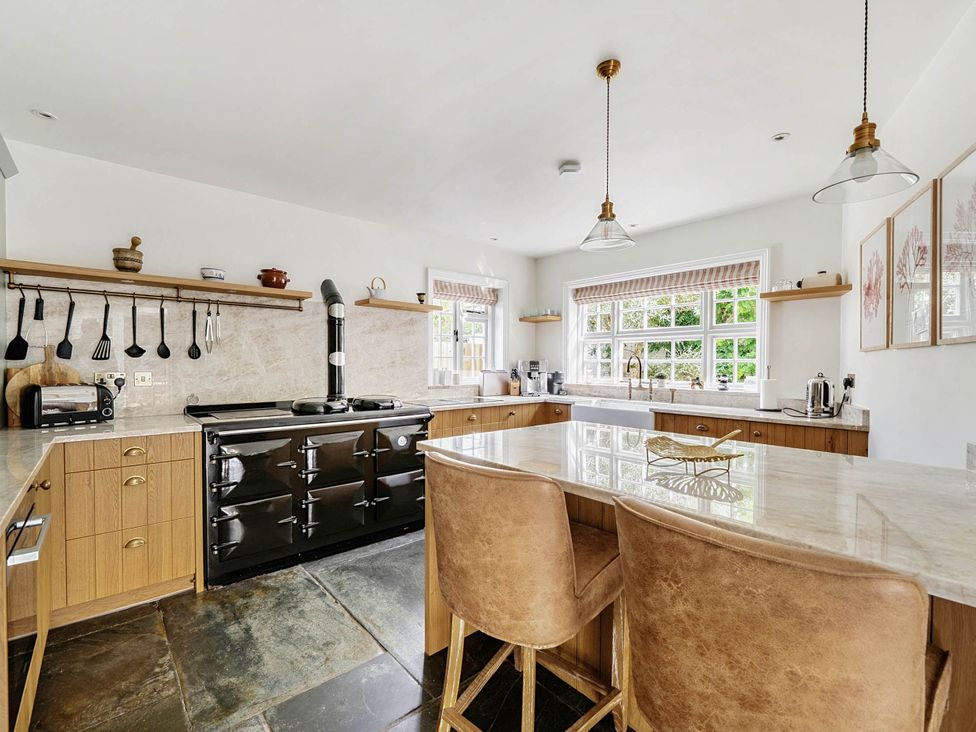 A kitchen with an island and stools at Vosporth Villa in Crantock