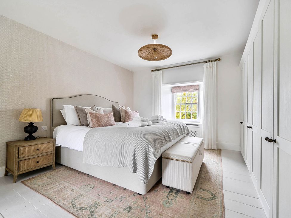 A bedroom with a bed and bedside table at Vosporth Villa in Crantock