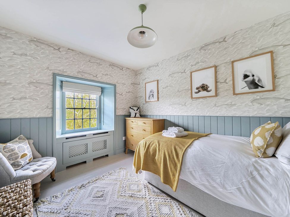 A bedroom with a bed and dresser at Vosporth Villa in Crantock