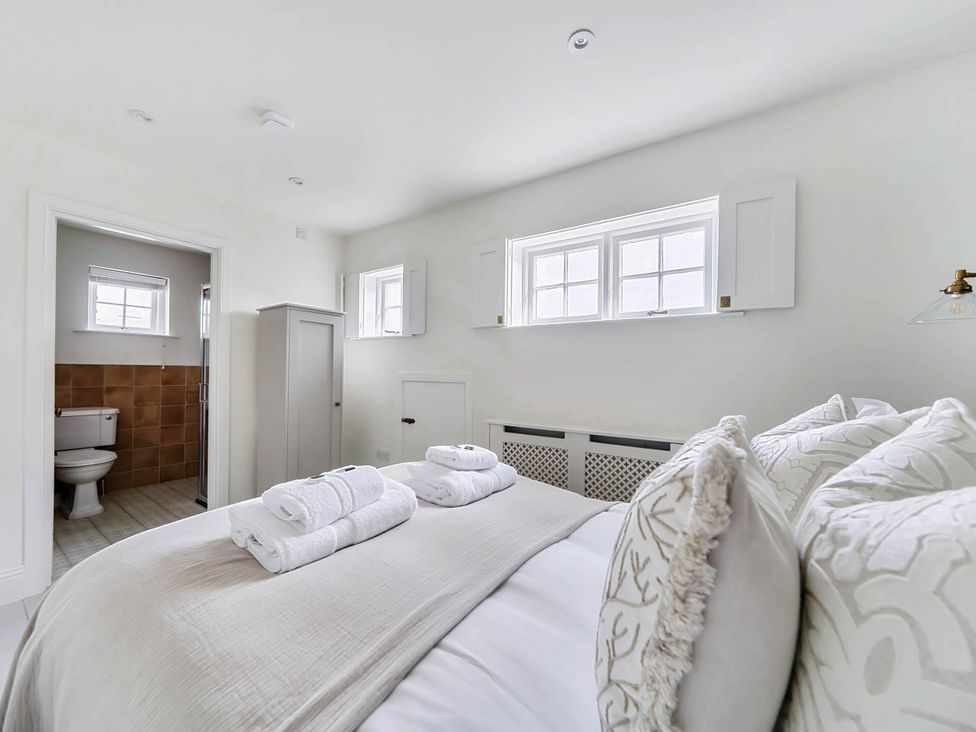 A bedroom with a bed and towels at Vosporth Villa in Crantock