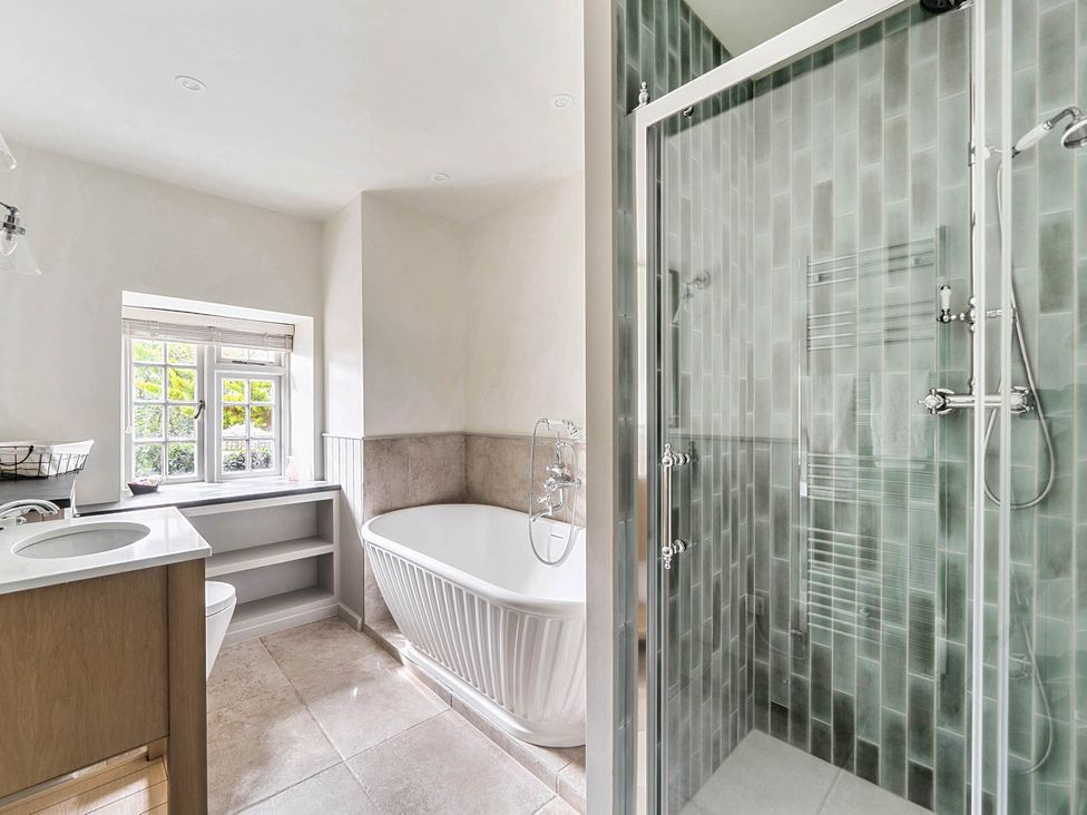 A bathroom with a bathtub, shower, and sink at Vosporth Villa in Crantock