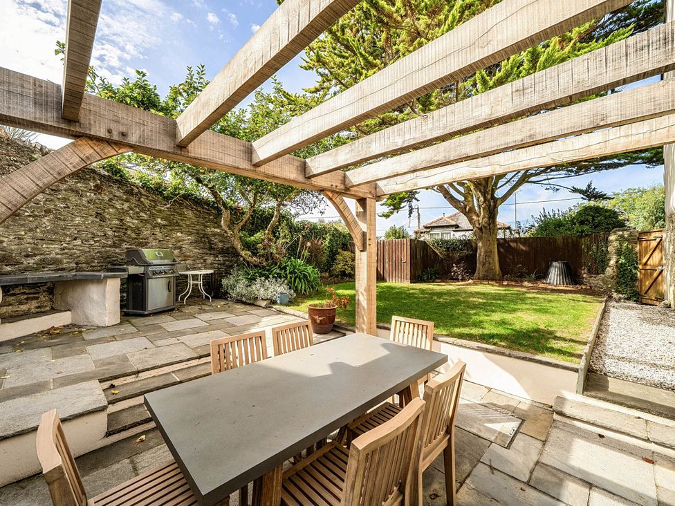A garden with a dining table and chairs at Vosporth Villa in Crantock