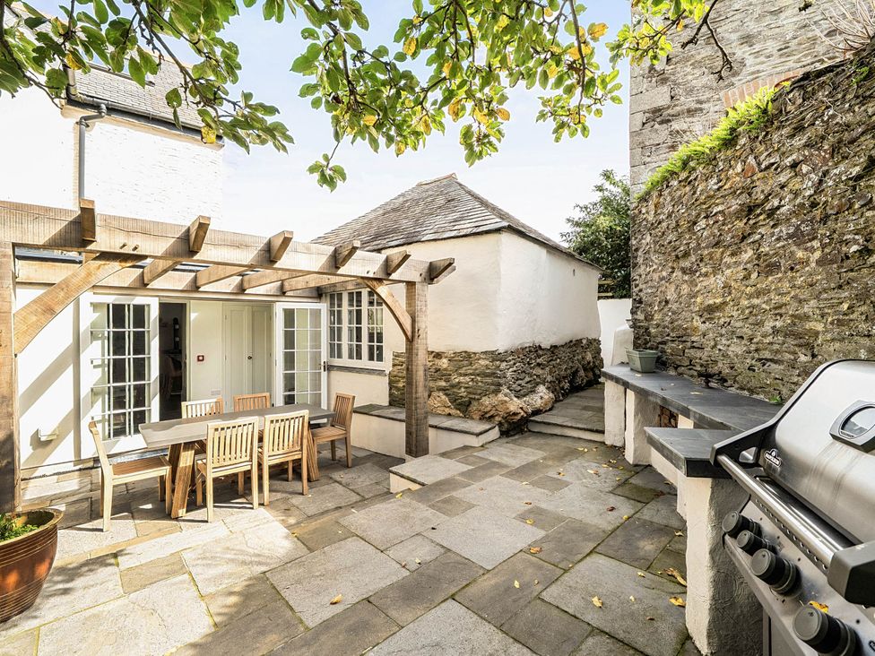 An outdoor patio with a table and chairs at Vosporth Villa in Crantock