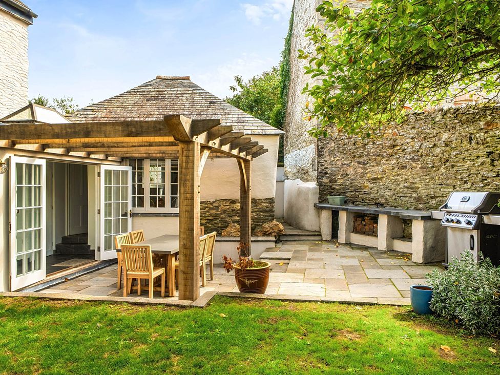 An outdoor area with a pergola and seating at Vosporth Villa in Crantock