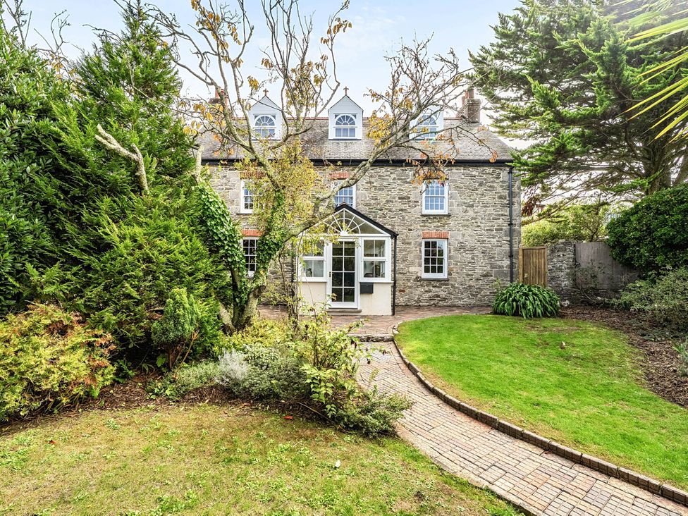 A garden with a house in the background at Vosporth Villa in Crantock