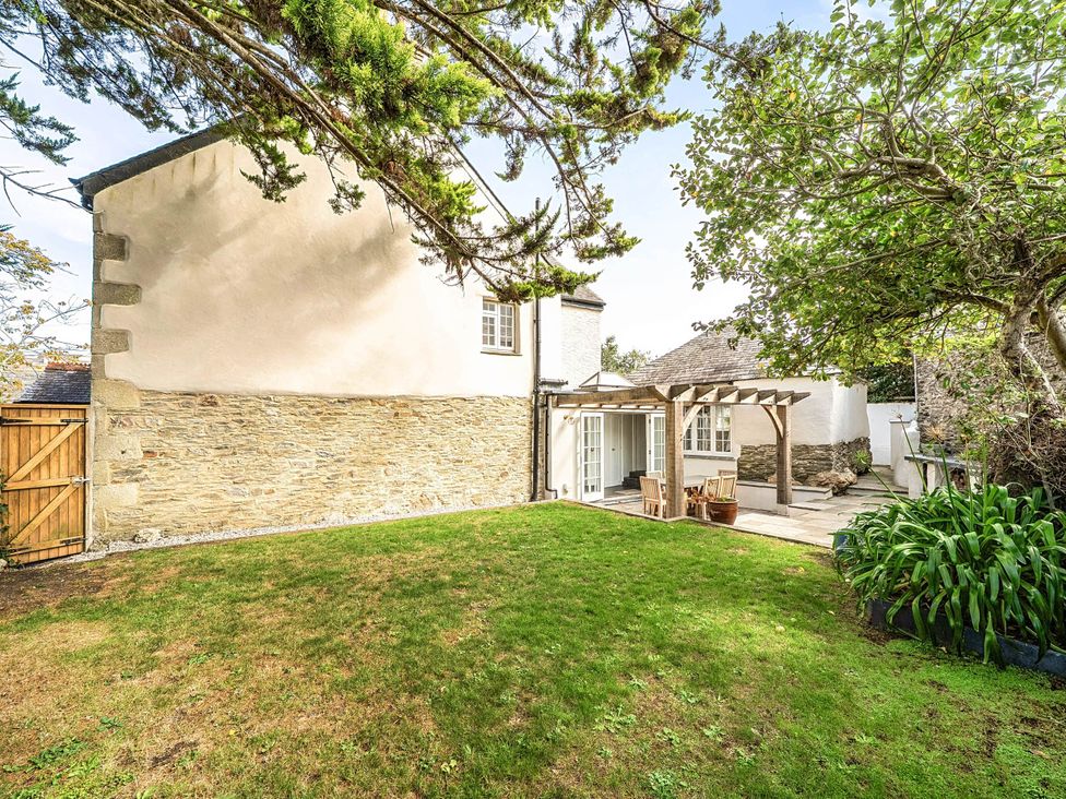 A garden with a pergola and a fence at Vosporth Villa in Crantock