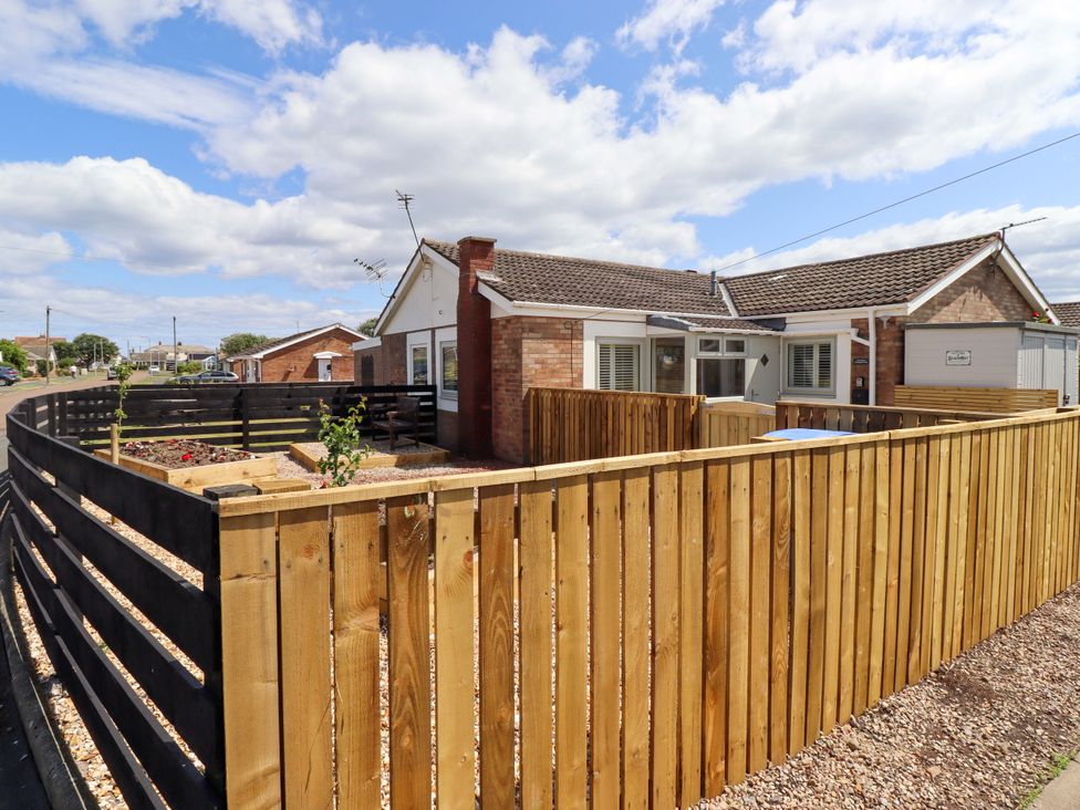 A house with a garden surrounded by a wooden fence at North Sands in Beadnell