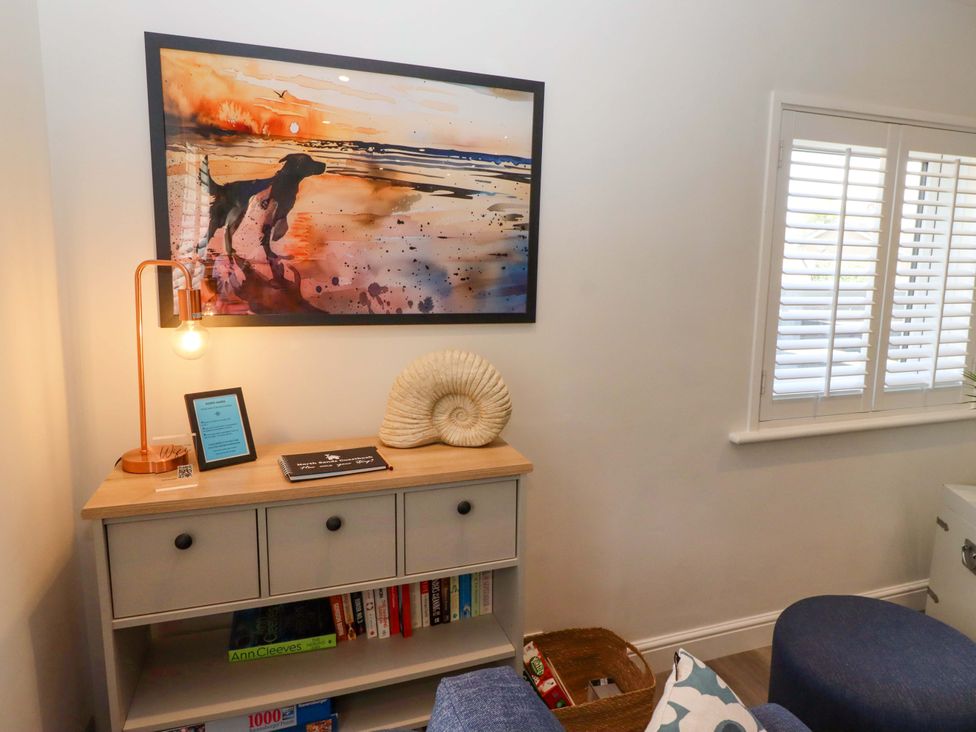 A living room with a table and lamp at North Sands in Beadnell