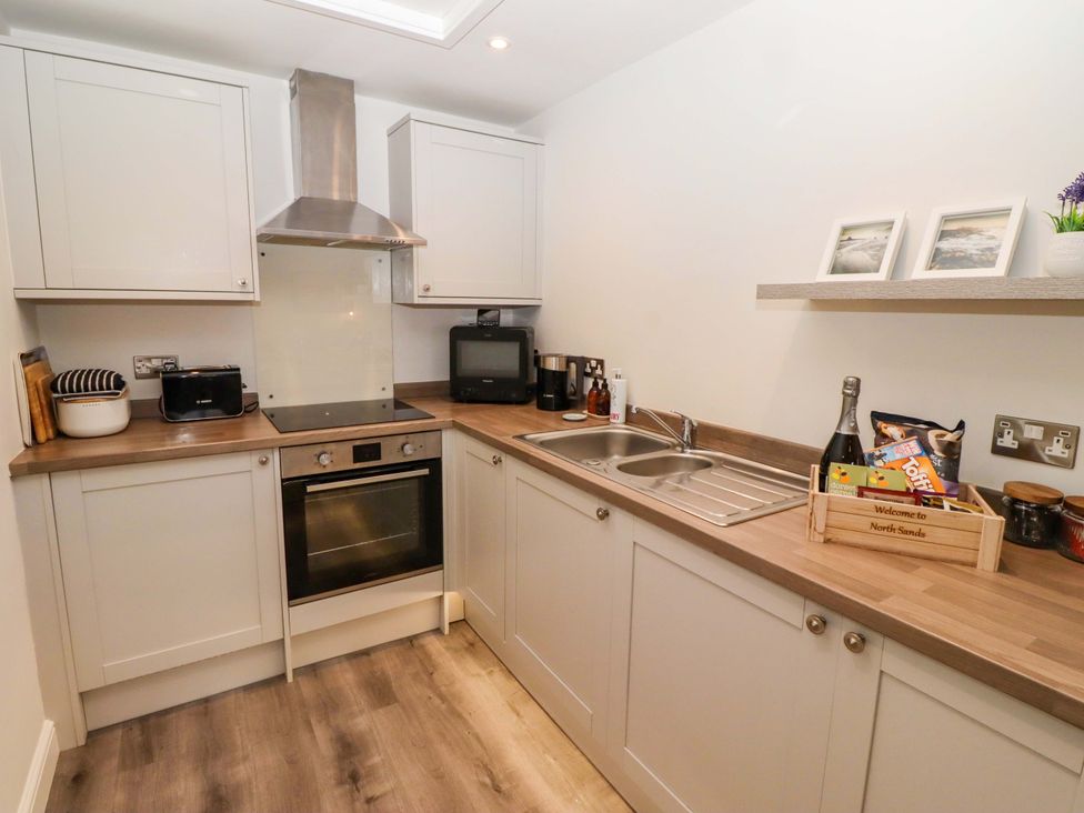 A kitchen with cabinets, oven, sink, and appliances at North Sands Beadnell