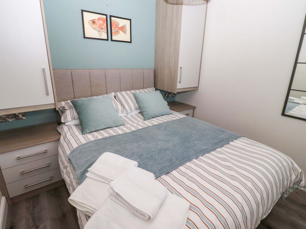 A bedroom with a bed and wardrobe at North Sands in Beadnell