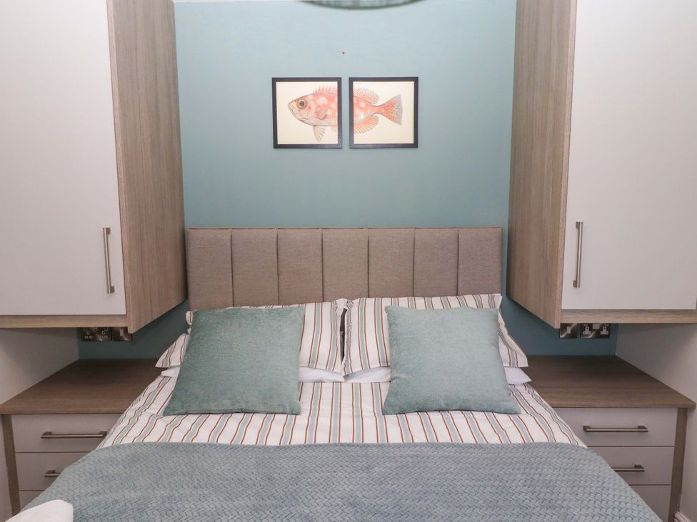 A bedroom with a bed and wall art at North Sands Beadnell