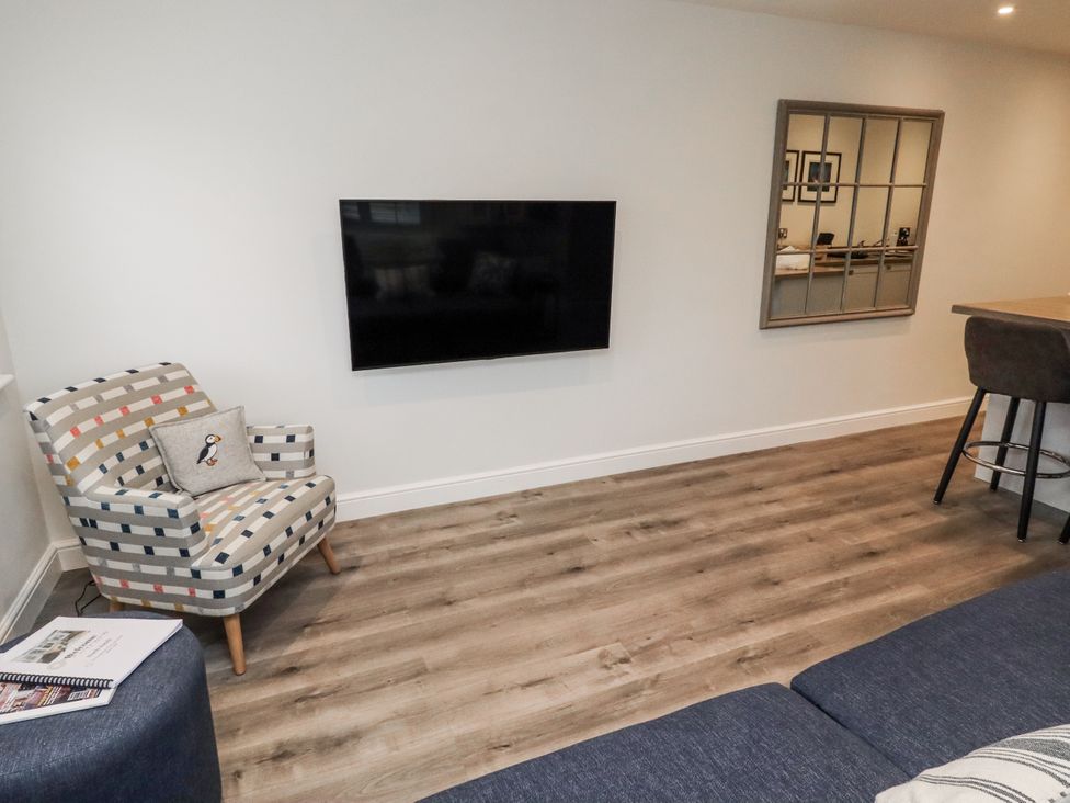 A living room with an armchair and television at North Sands in Beadnell