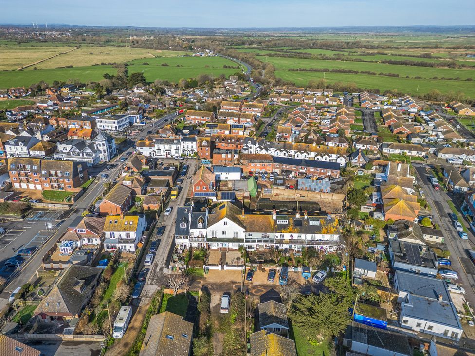 An aerial view of a residential area with houses and fields at Marine House Pevensey Bay