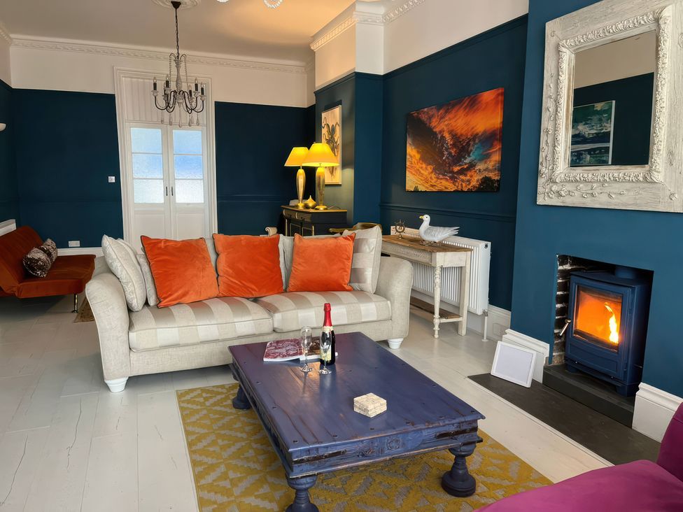 A living room with a sofa and coffee table at Marine House Pevensey Bay