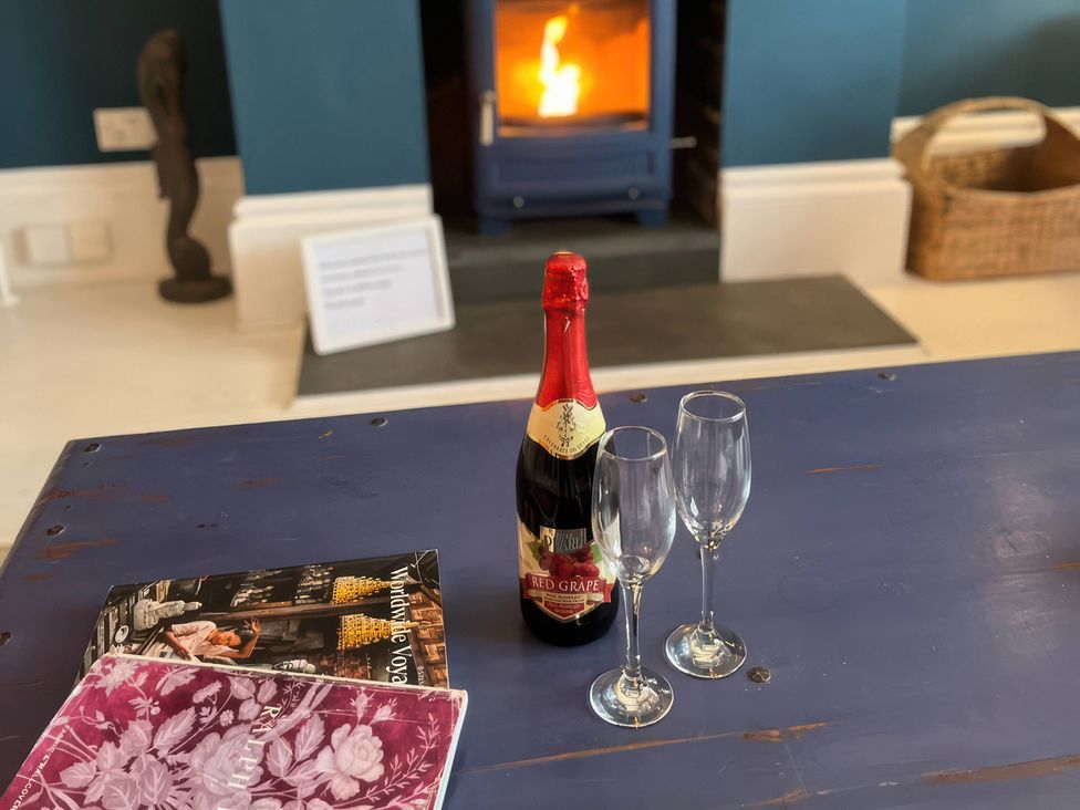 A living room with a bottle of wine and two champagne glasses at Marine House Pevensey Bay