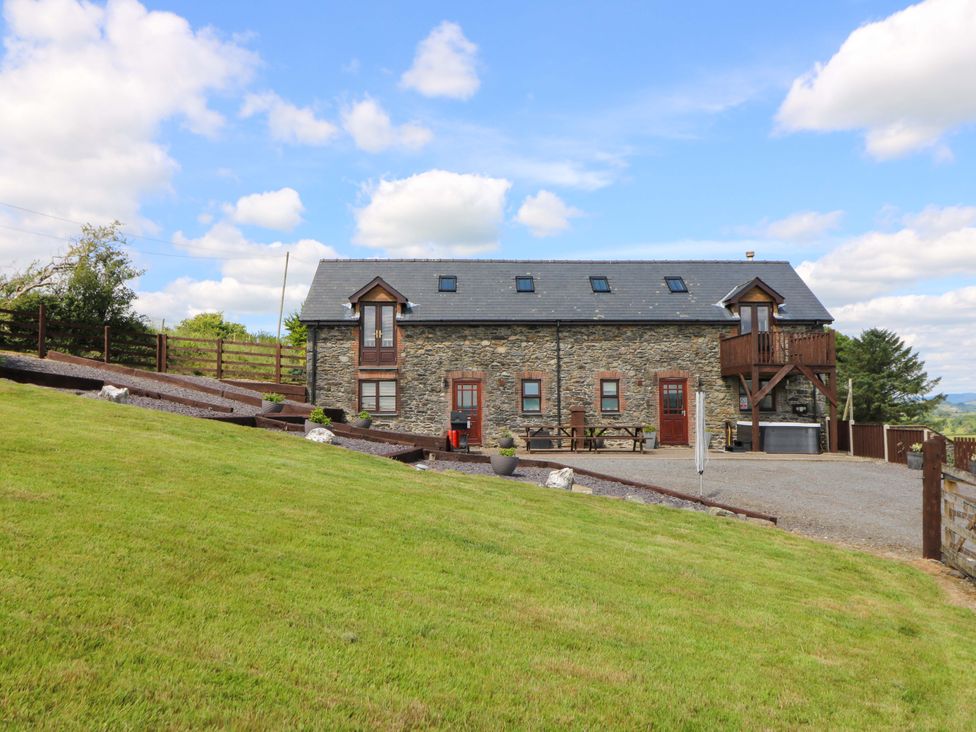 A house with a stone exterior and gravel driveway at Llwyngwinau Isaf Barn Tynreithyn near Tregaron